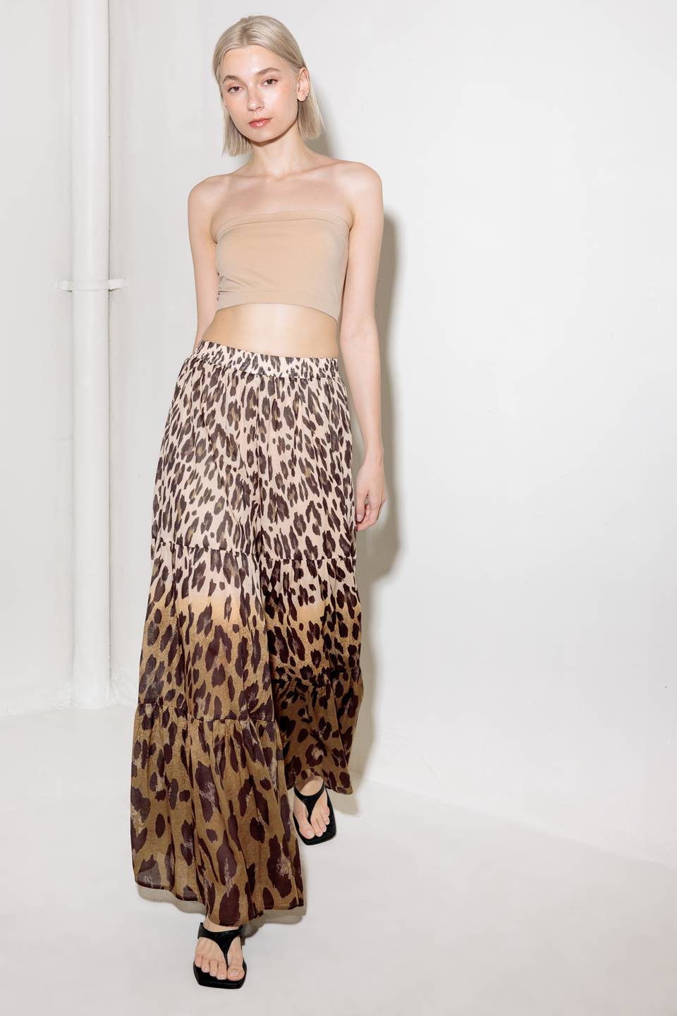 A printed woven pant featuring smocked waistband and tiered bottom with wide leg.
