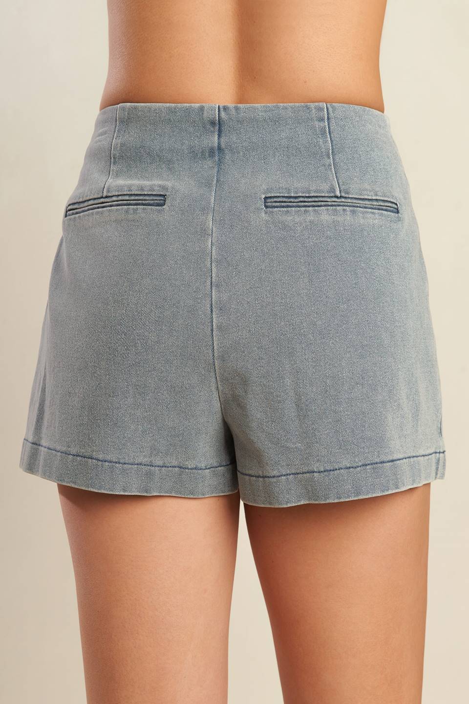 A solid denim mini skort with side zipper closure and back pockets.