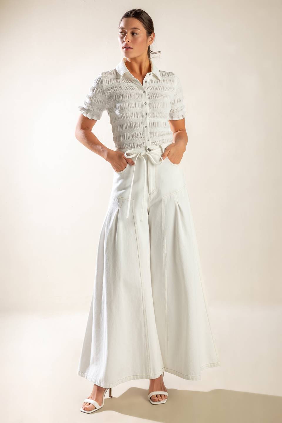 These white woven pants include a front closure, pockets, self-tie skinny belt, side pleats, and an extra wide leg for added comfort.