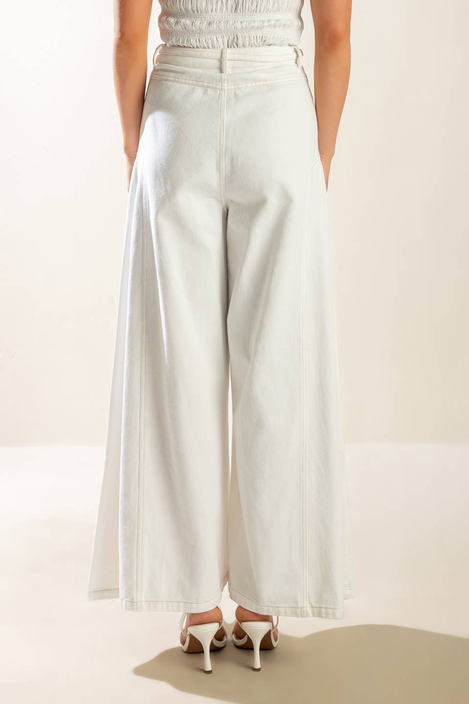 These white woven pants include a front closure, pockets, self-tie skinny belt, side pleats, and an extra wide leg for added comfort.