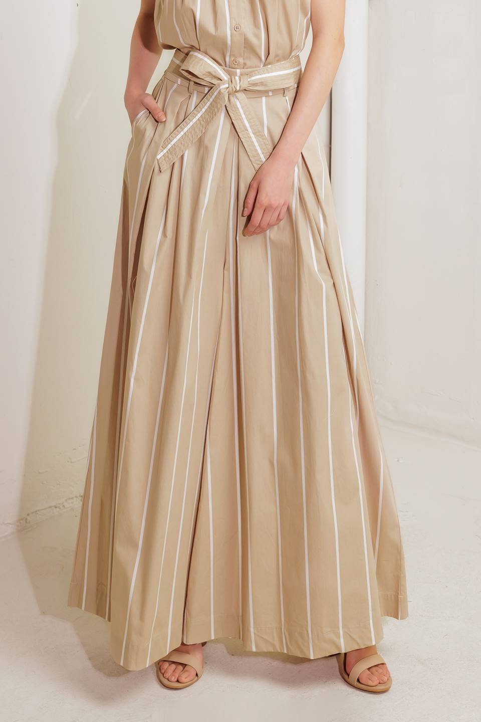 A striped woven pant featuring front pleat, self sash tie and extra wide leg.