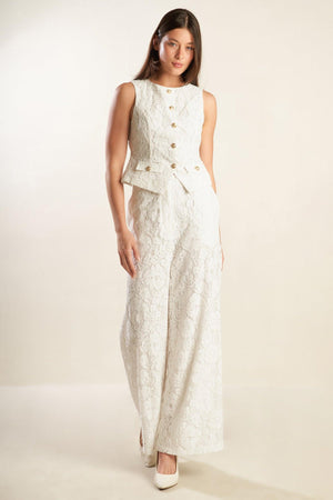 A white woven lace pant featuring side pockets, belt loops, front closure and wide leg.