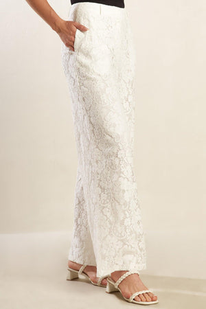 A white woven lace pant featuring side pockets, belt loops, front closure and wide leg.