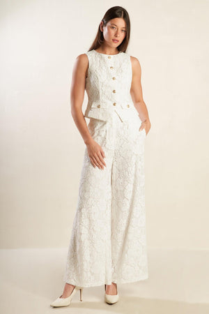 A white woven lace pant featuring side pockets, belt loops, front closure and wide leg.