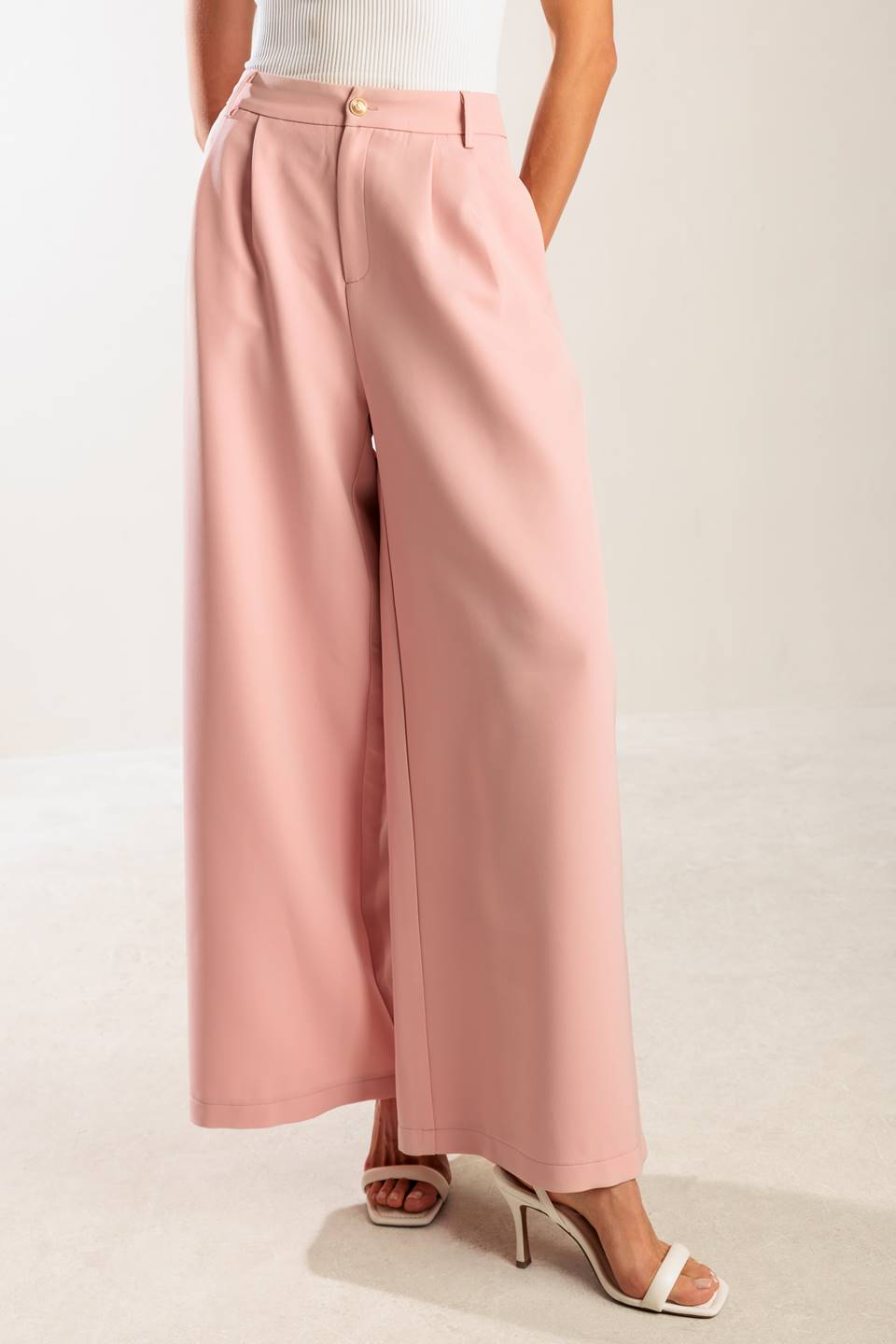 A solid woven pant featuring front closure, side pockets, and wide leg.