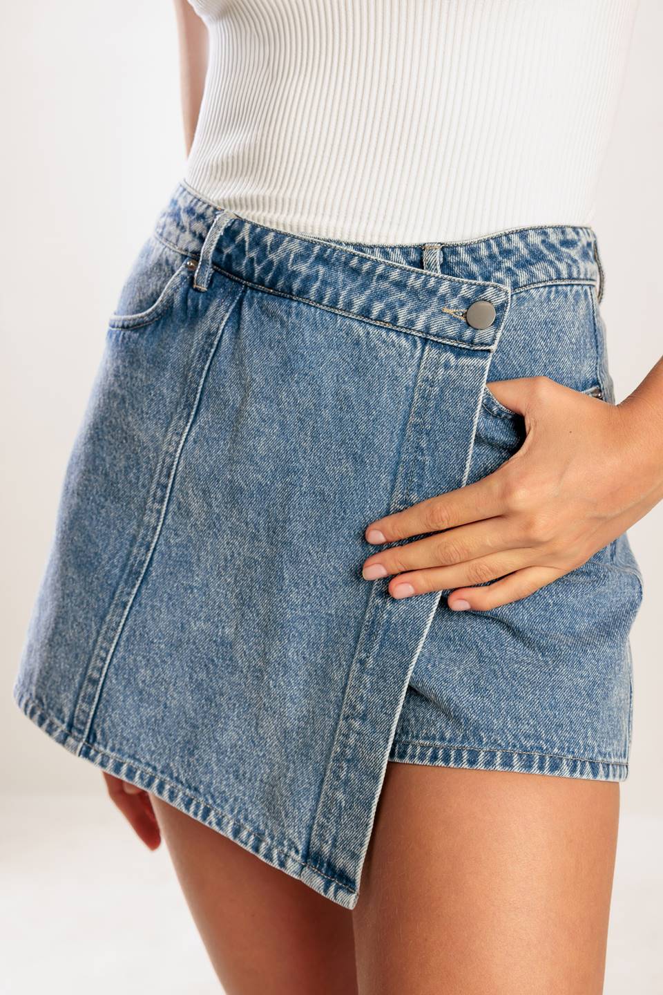 A washed denim blue skort with pockets and front closure.