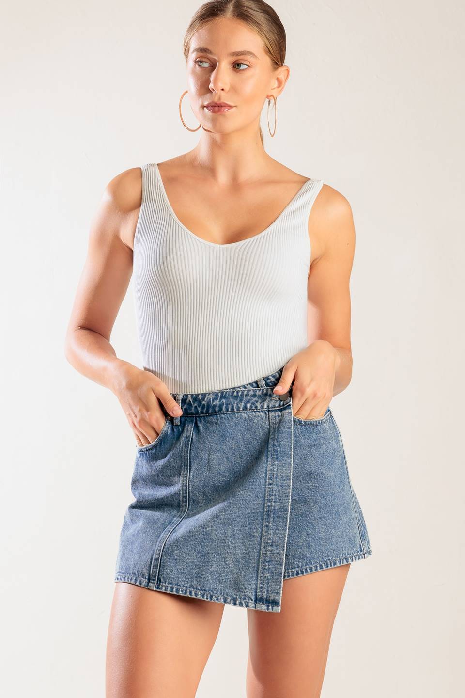 A washed denim blue skort with pockets and front closure.