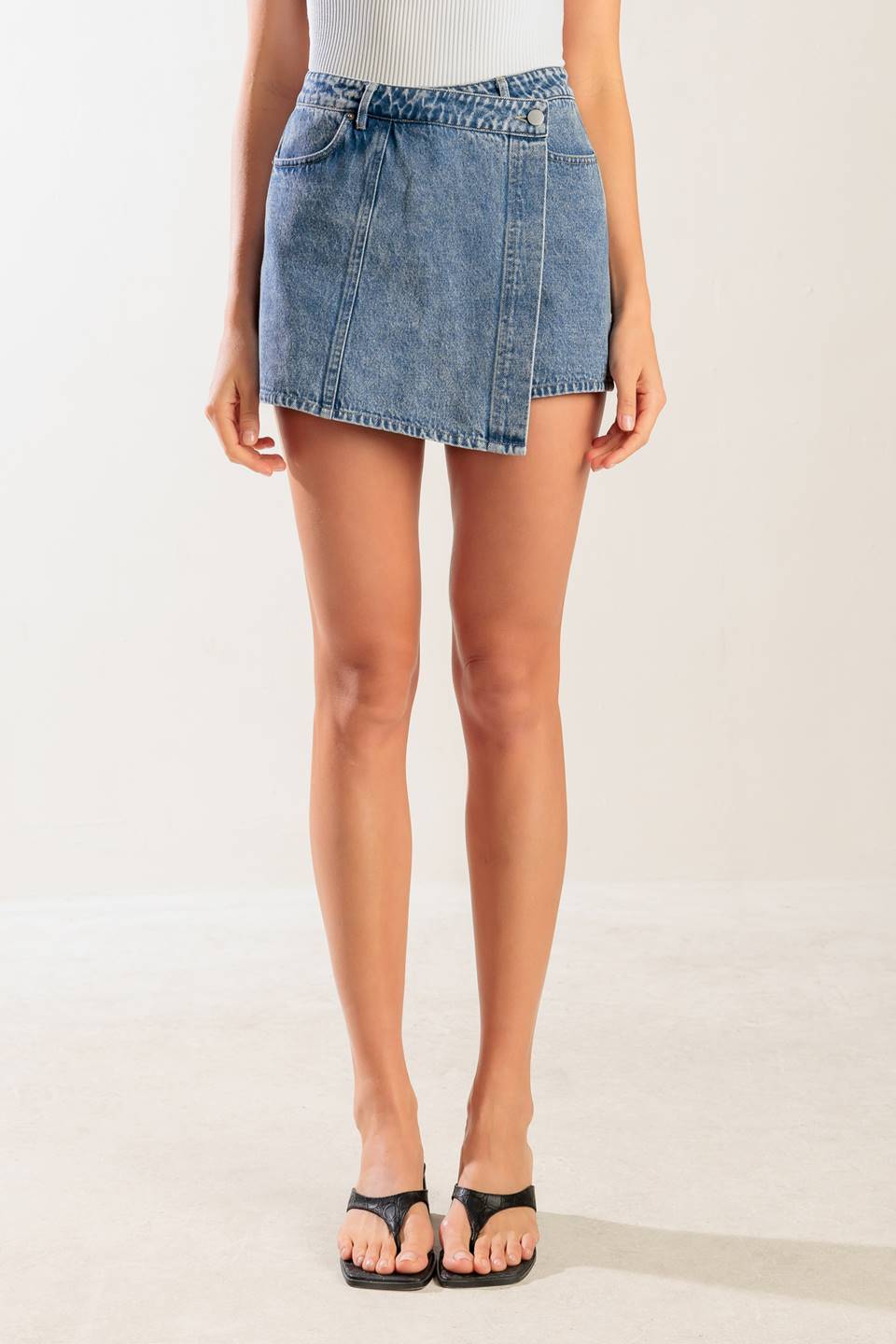 A washed denim blue skort with pockets and front closure.