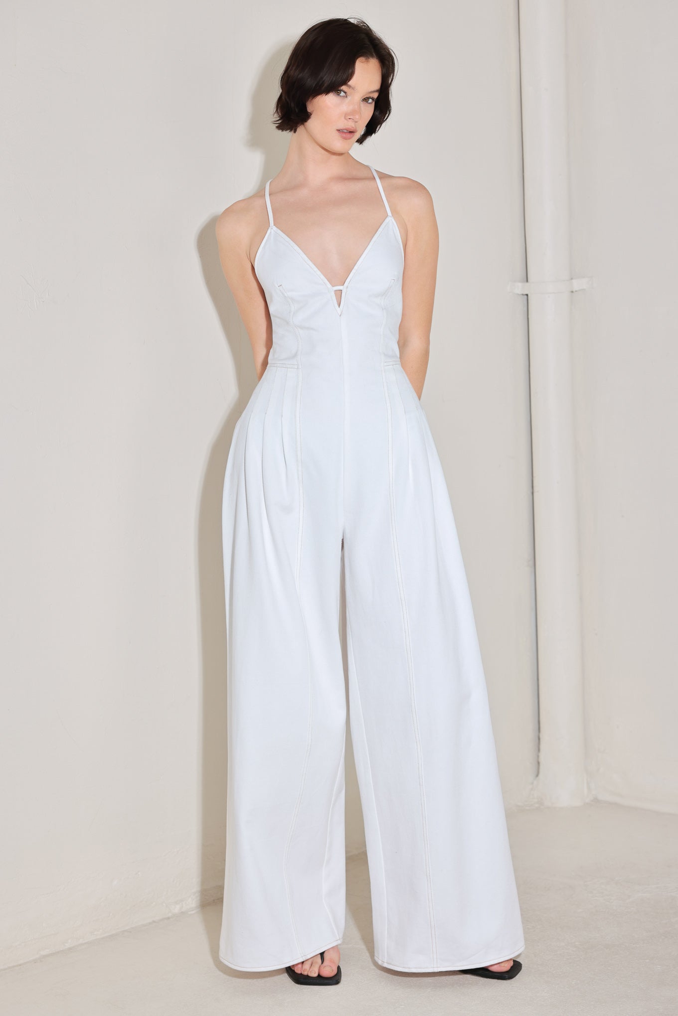 
A solid woven jumpsuit featuring cami top, side pleats, wide leg, bare back with cross straps and zipper closure

Details:

Self : 100% Cotton

Size &amp; Fit

- Model is 5`8" And Wearing Size Small
- Measurements Taken From Size Small
- Approx. Length: 58"