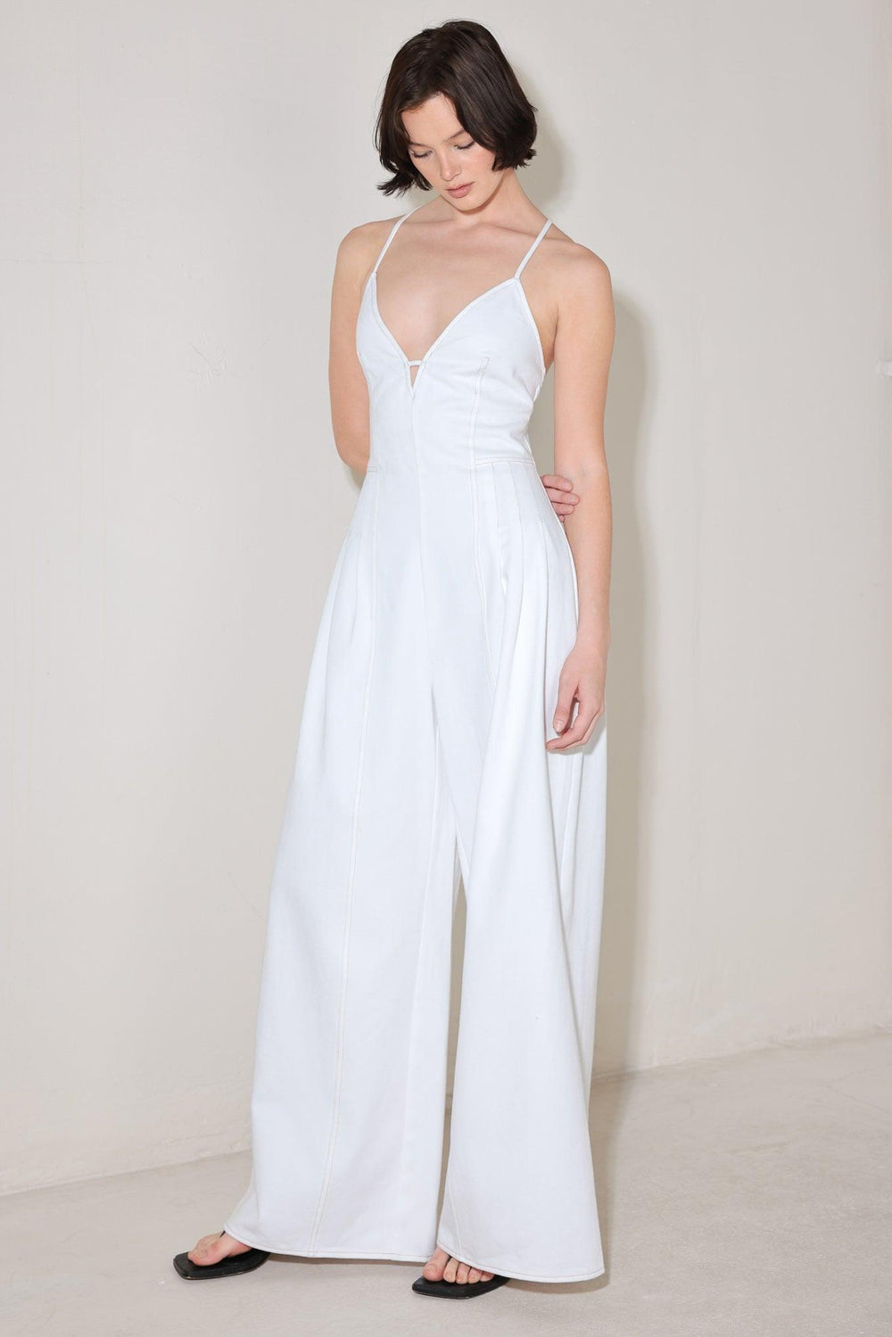 
A solid woven jumpsuit featuring cami top, side pleats, wide leg, bare back with cross straps and zipper closure

Details:

Self : 100% Cotton

Size &amp; Fit

- Model is 5`8" And Wearing Size Small
- Measurements Taken From Size Small
- Approx. Length: 58"
