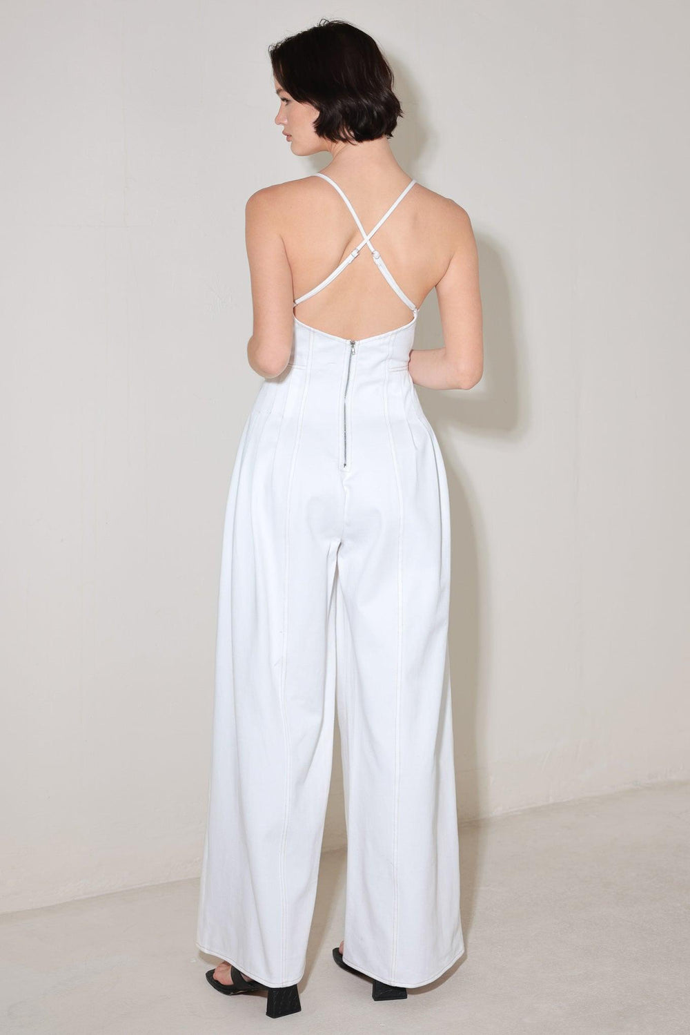 
A solid woven jumpsuit featuring cami top, side pleats, wide leg, bare back with cross straps and zipper closure

Details:

Self : 100% Cotton

Size &amp; Fit

- Model is 5`8" And Wearing Size Small
- Measurements Taken From Size Small
- Approx. Length: 58"
