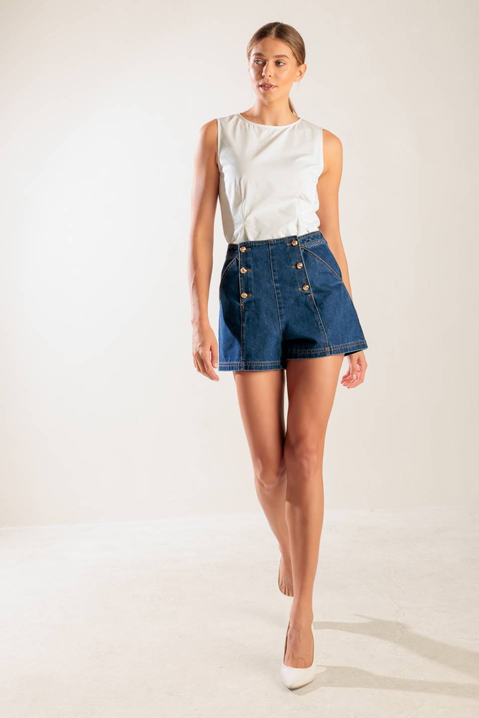 A denim short featuring front double button closure and front/back pockets.