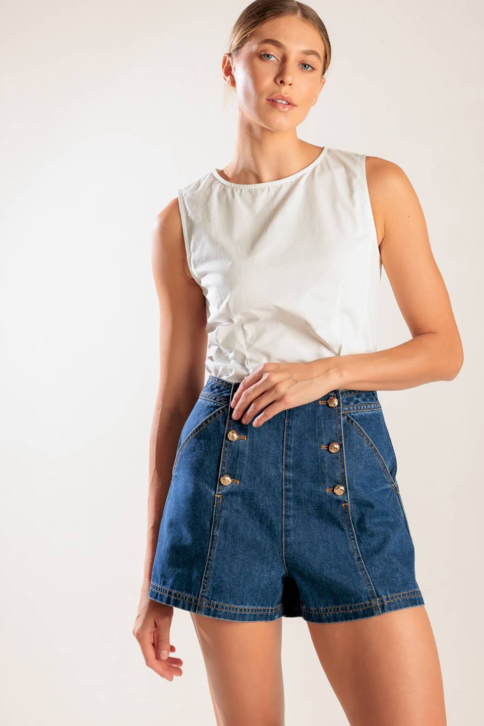 A denim short featuring front double button closure and front/back pockets.