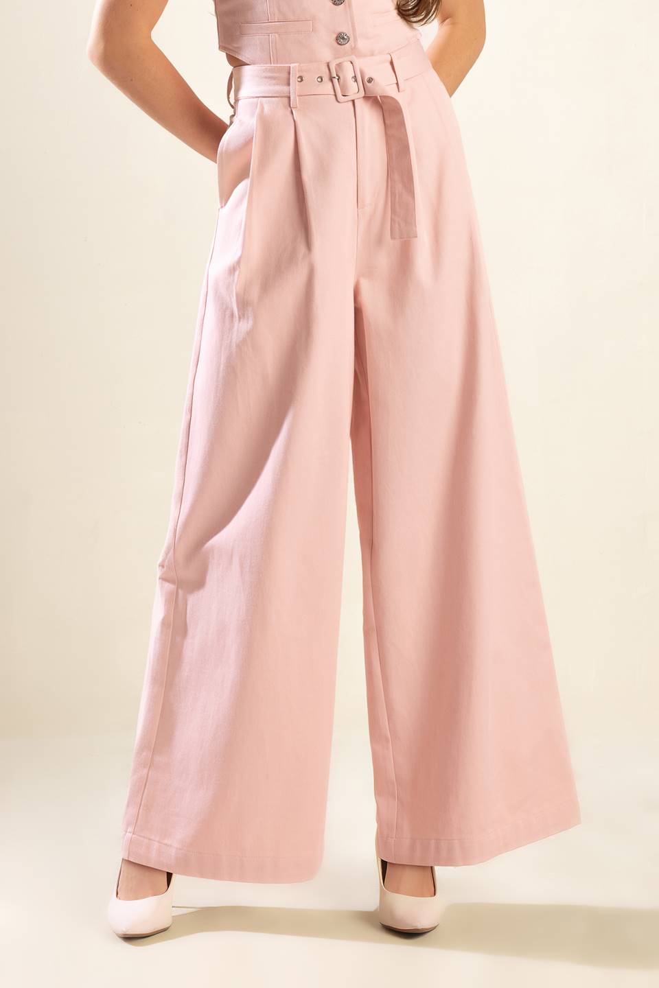 Constructed from high-quality woven material, these pink pants boast a stylish front closure, a convenient self belt, functional pockets, and a flattering wide leg design.