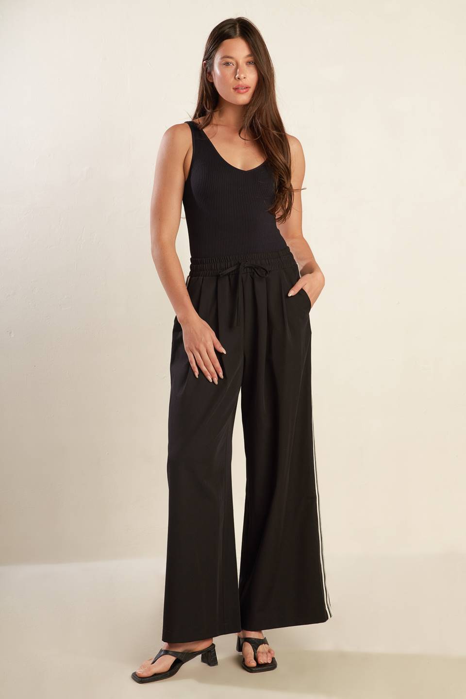 
A solid woven pant featuring elasticized waist with tie front, wide leg and stipe side detail. Matching top FT1519

Self : 74% Polyester 20% Rayon 6% Spandex

Size &amp; Fit

- Model is 5`8" And Wearing Size Small
- Measurements Taken From Size Small
- Approx. Length: 44"