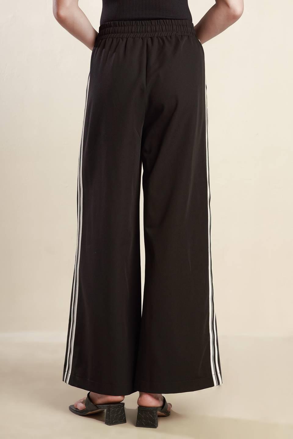 A solid woven pant featuring elasticized waist with tie front, wide leg and stipe side detail. Matching top FT1519
Self : 74% Polyester 20% Rayon 6% Spandex
Size & Fit
- Model is 5`8" And Wearing Size Small
- Measurements Taken From Size Small
- Approx. Length: 44"