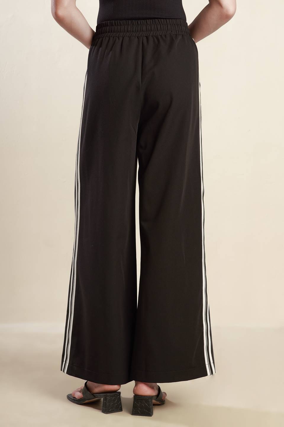 
A solid woven pant featuring elasticized waist with tie front, wide leg and stipe side detail. Matching top FT1519

Self : 74% Polyester 20% Rayon 6% Spandex

Size &amp; Fit

- Model is 5`8" And Wearing Size Small
- Measurements Taken From Size Small
- Approx. Length: 44"