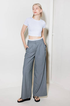 A striped woven pant featuring contrasting edge waist band, front pleat, side pockets, side stripe detail and wide leg.