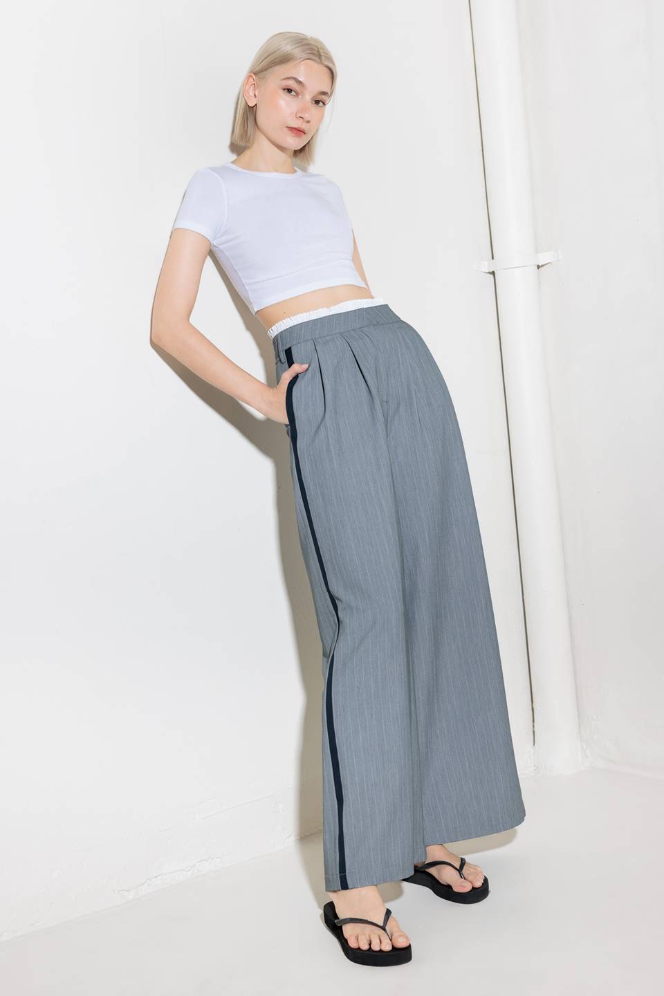 A striped woven pant featuring contrasting edge waist band, front pleat, side pockets, side stripe detail and wide leg.
