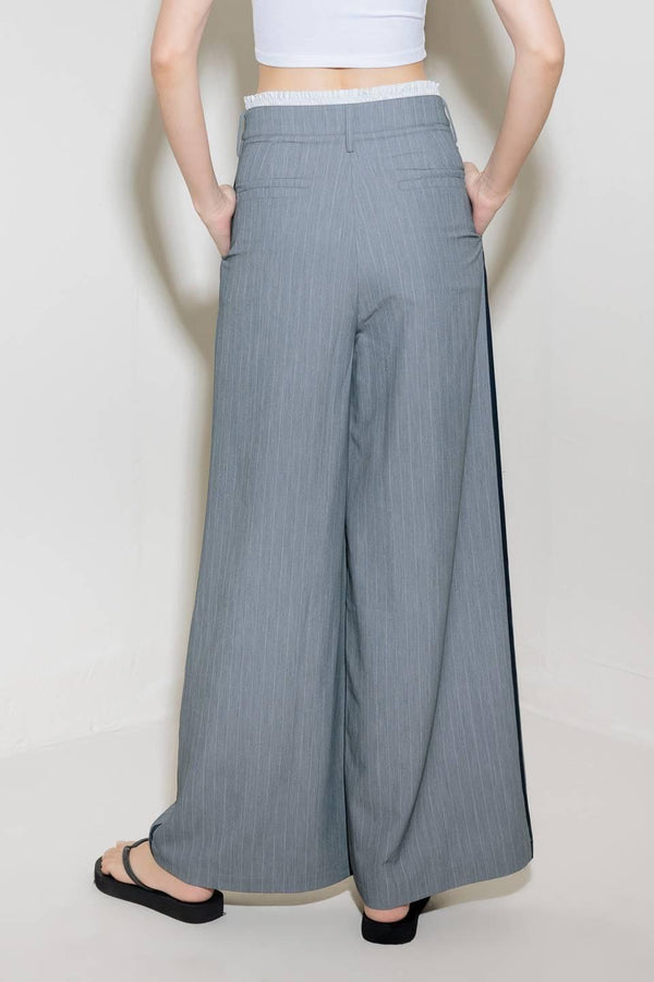 A striped woven pant featuring contrasting edge waist band, front pleat, side pockets, side stripe detail and wide leg.