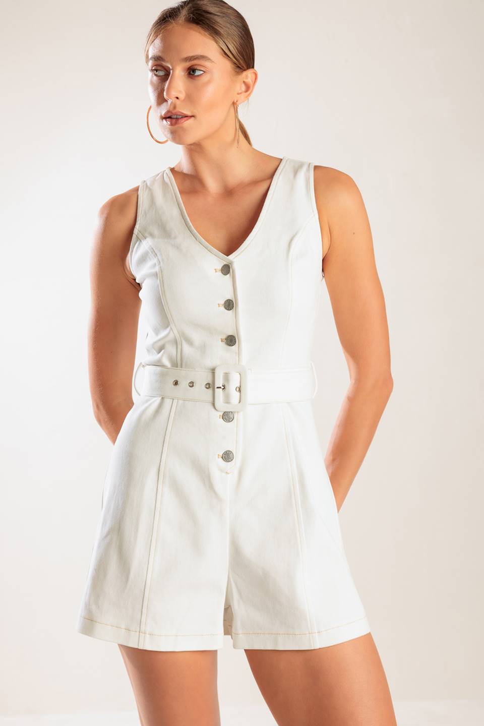 A solid white woven romper featuring V neckline, sleeveless, button down closure and self belt