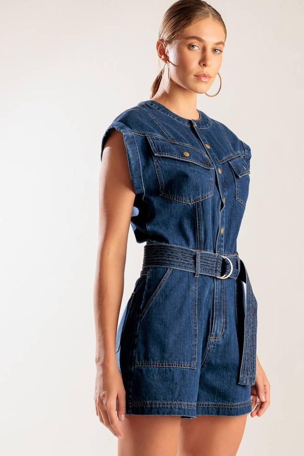 A denim romper featuring a round neckline, button down, cuffed sleeve, self belt, and pockets.