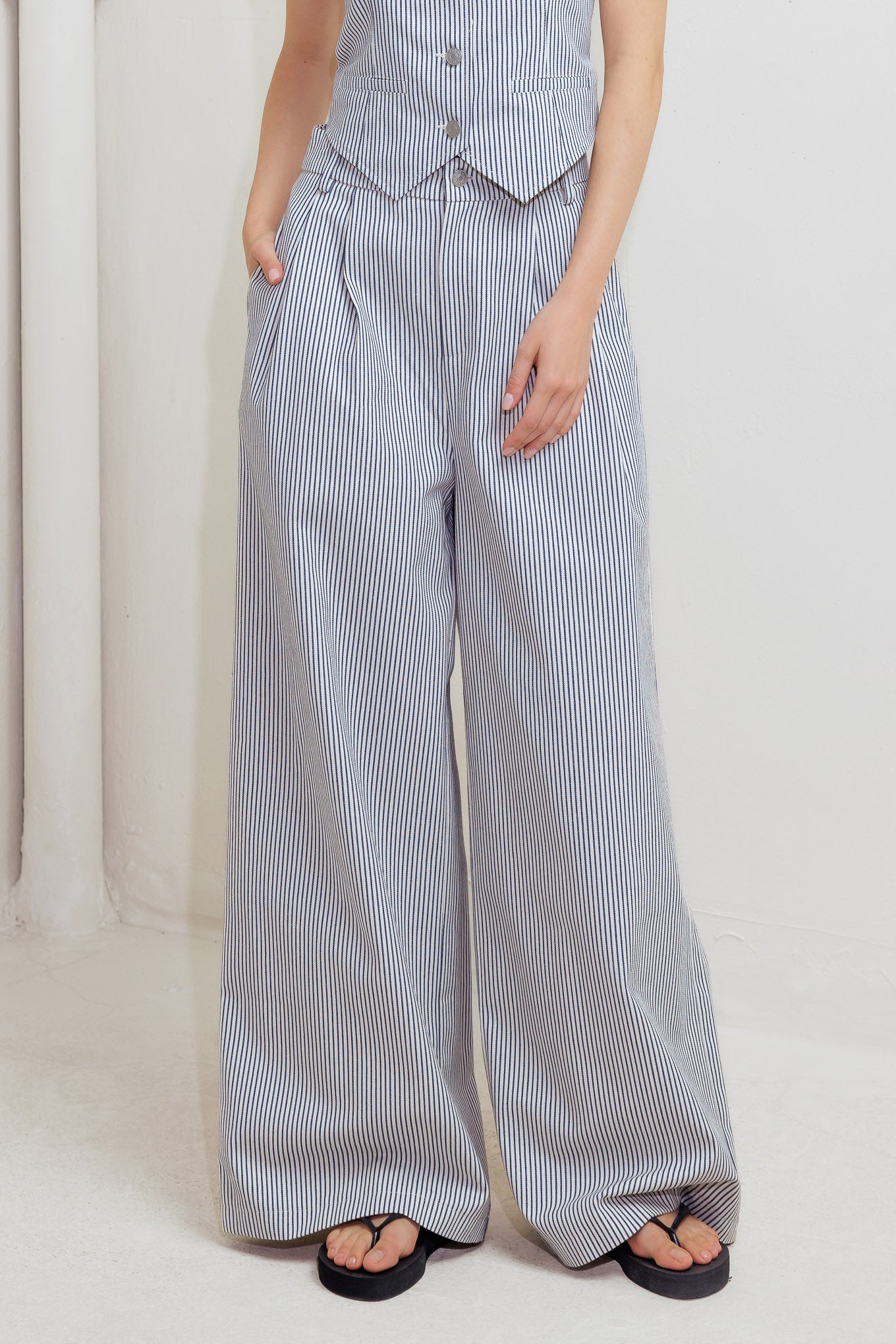 A striped woven pant featuring front closure, pockets and wide leg.