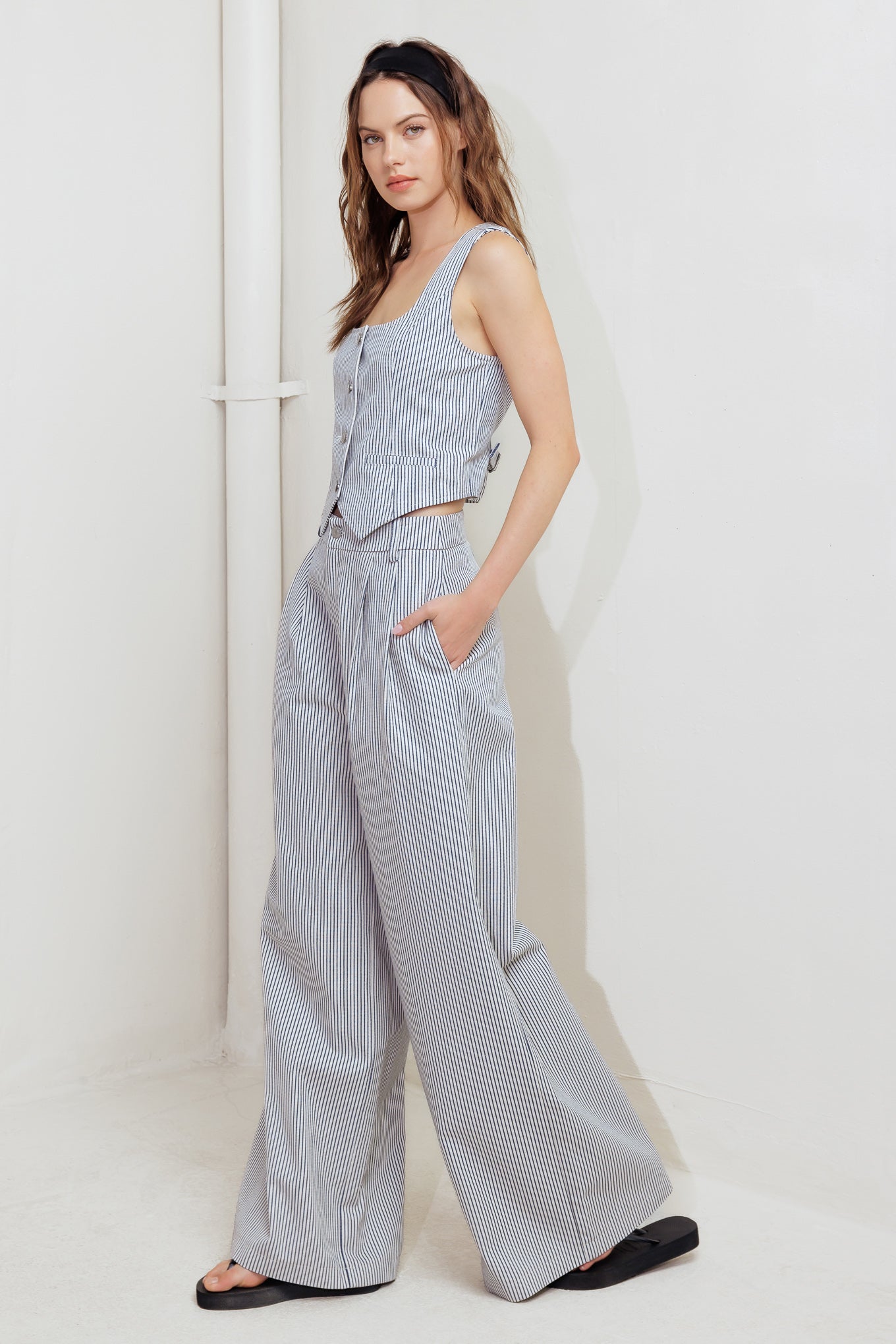 A striped woven pant featuring front closure, pockets and wide leg.