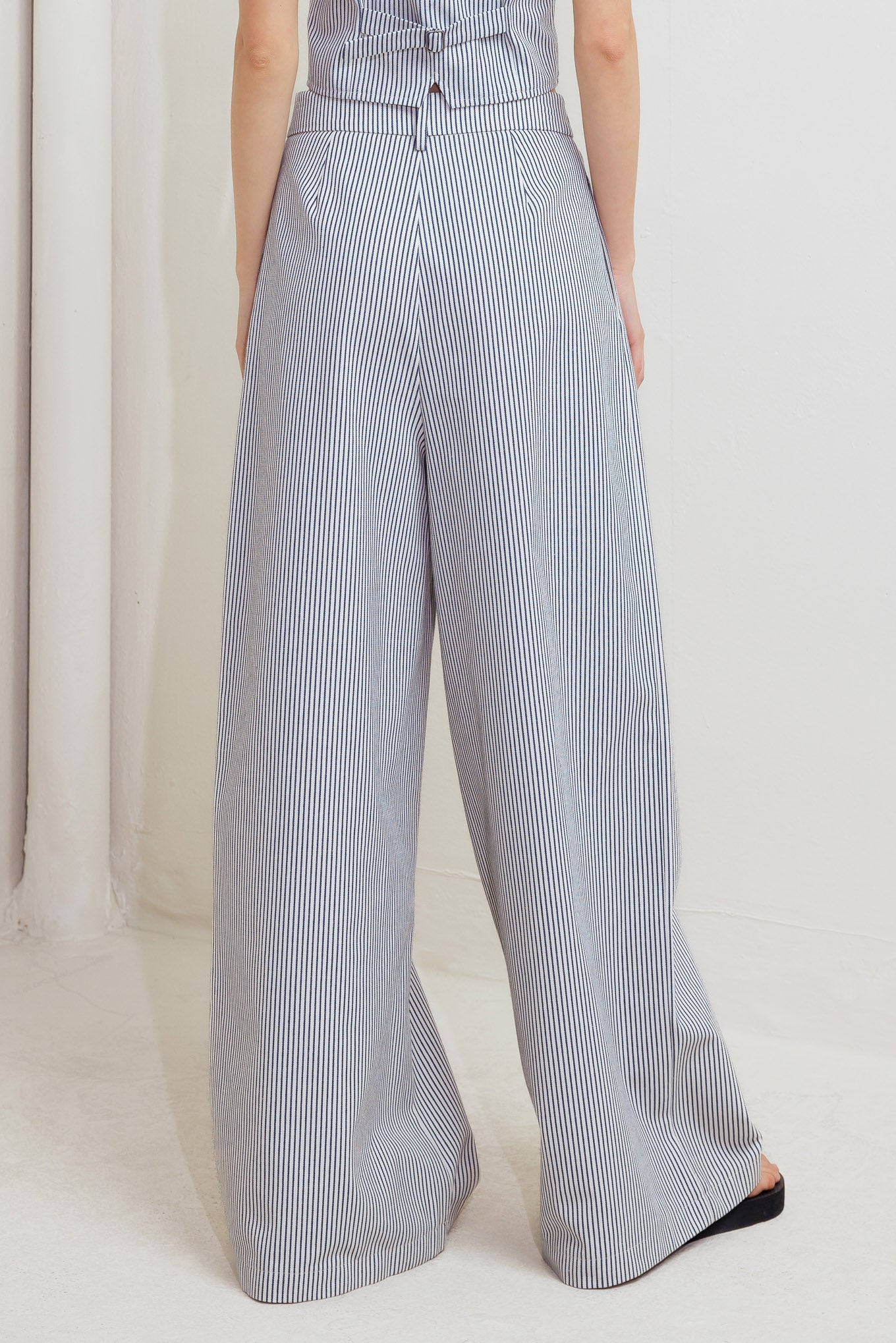 A striped woven pant featuring front closure, pockets and wide leg.