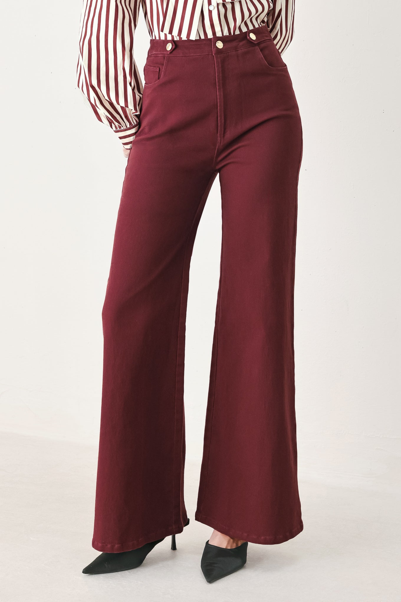 A woman wearing high-waisted burgundy wide-leg trouser pants with front closure and pockets | FREEMARKET