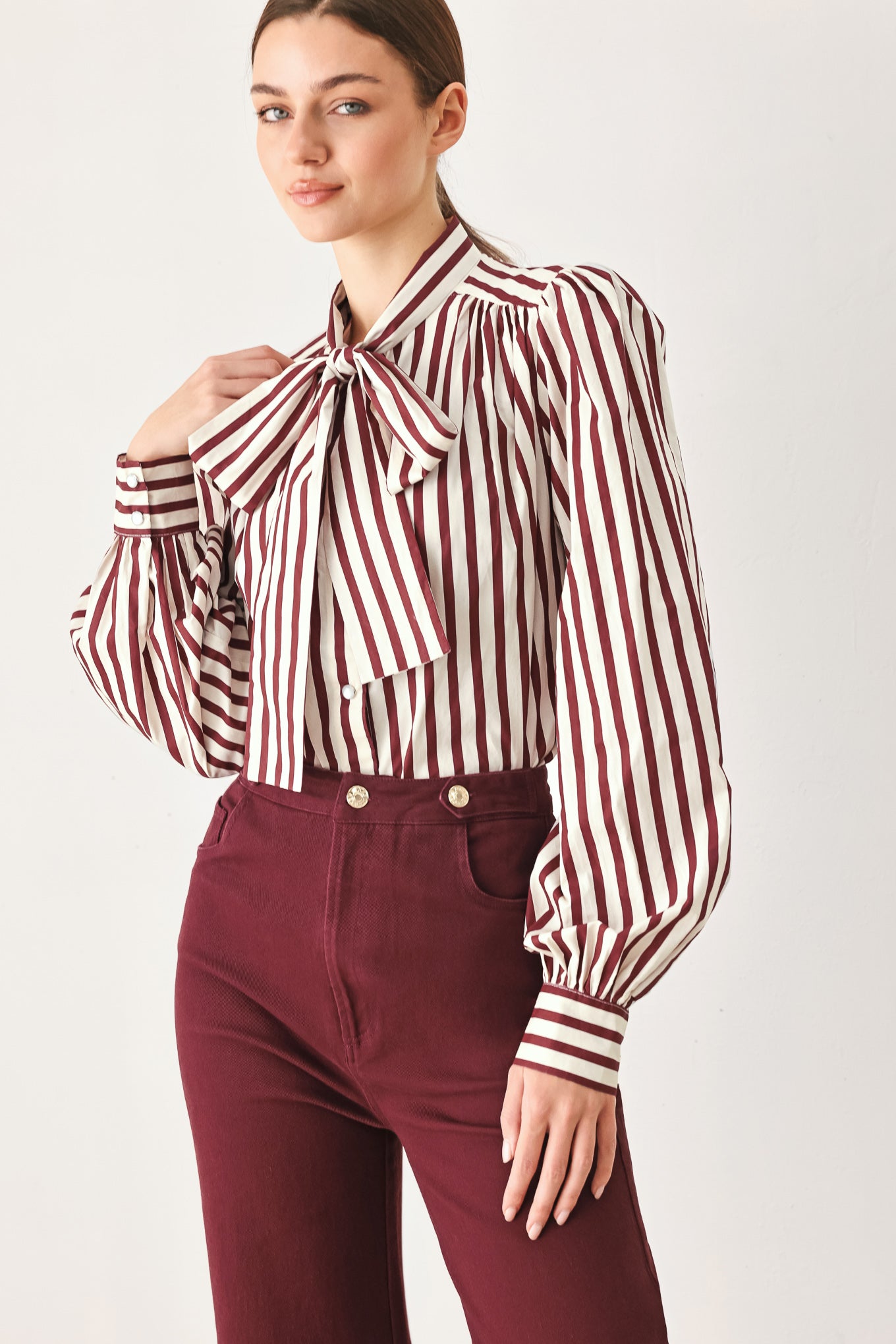 A woman wearing high-waisted burgundy wide-leg trouser pants with front closure and pockets | FREEMARKET