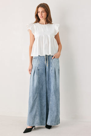 Light blue wide-leg denim pants with pleated front panels, side pockets, and a cream drawstring waist, shown on a model | FREEMARKET