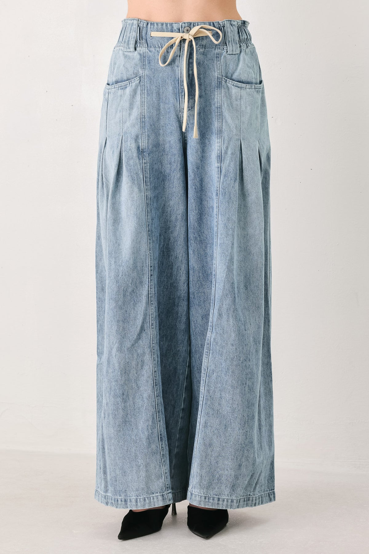 Light blue wide-leg denim pants with pleated front panels, side pockets, and a cream drawstring waist, shown on a model | FREEMARKET