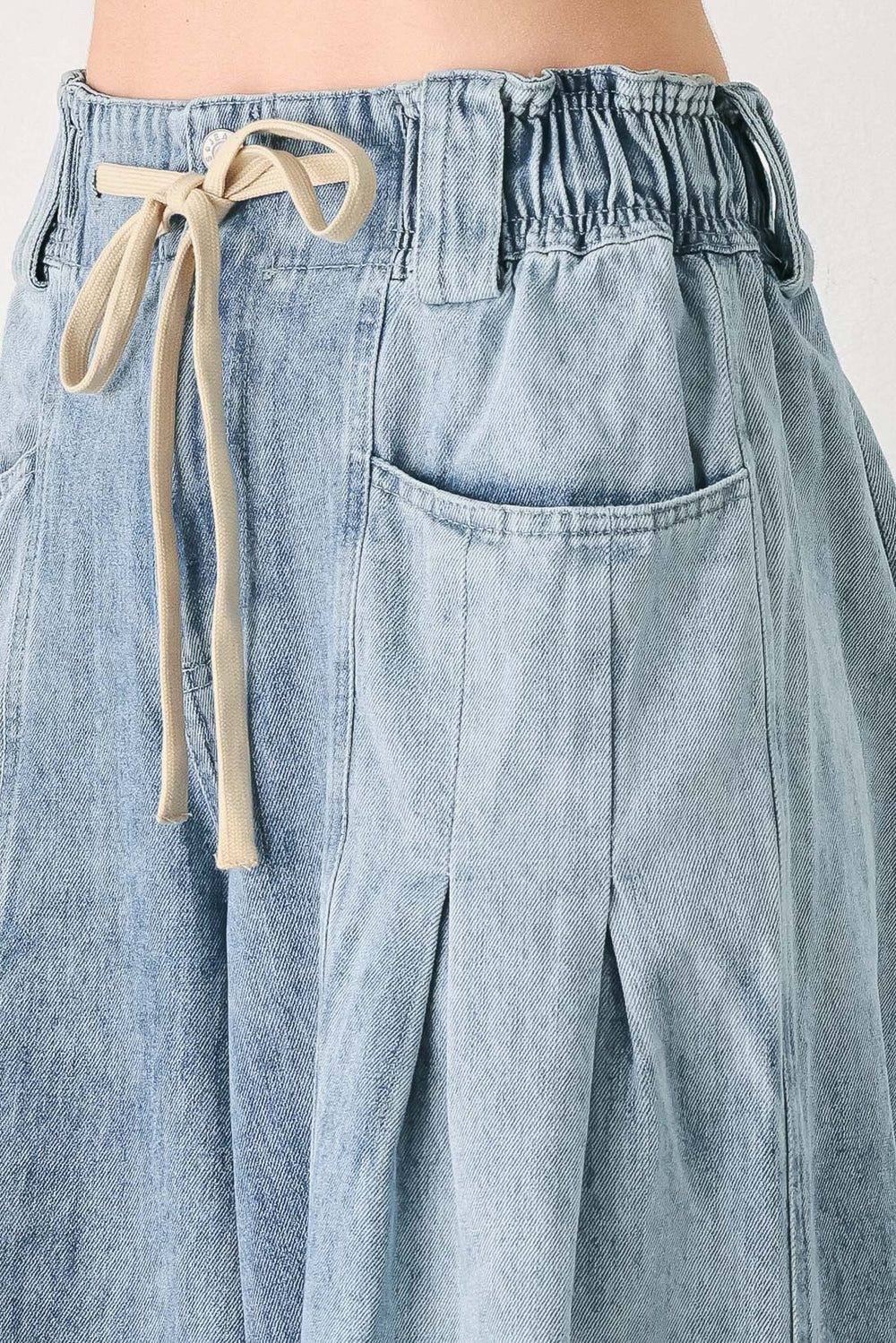 Light blue wide-leg denim pants with pleated front panels, side pockets, and a cream drawstring waist, shown on a model | FREEMARKET