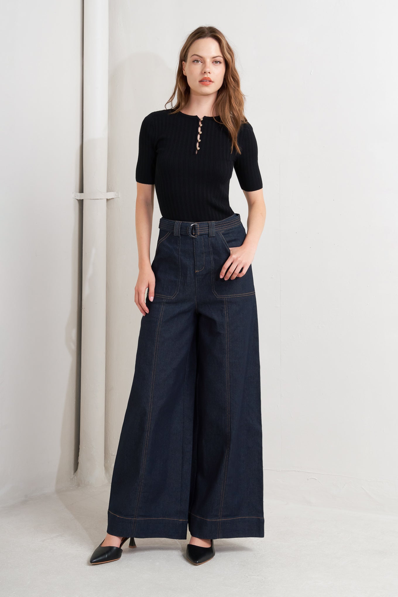 A denim pant featuring front closure, side pockets, self belt and wide