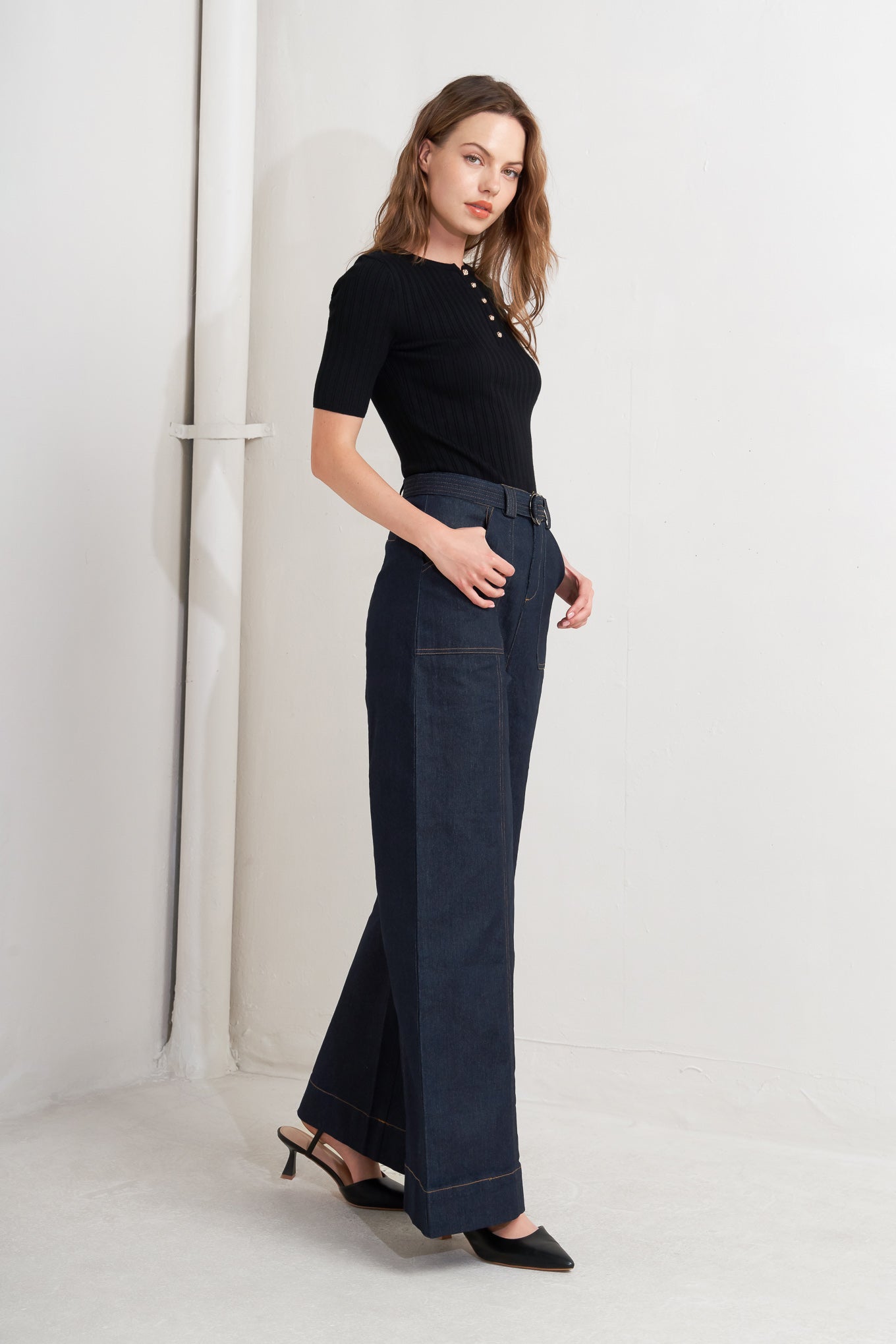 A denim pant featuring front closure, side pockets, self belt and wide