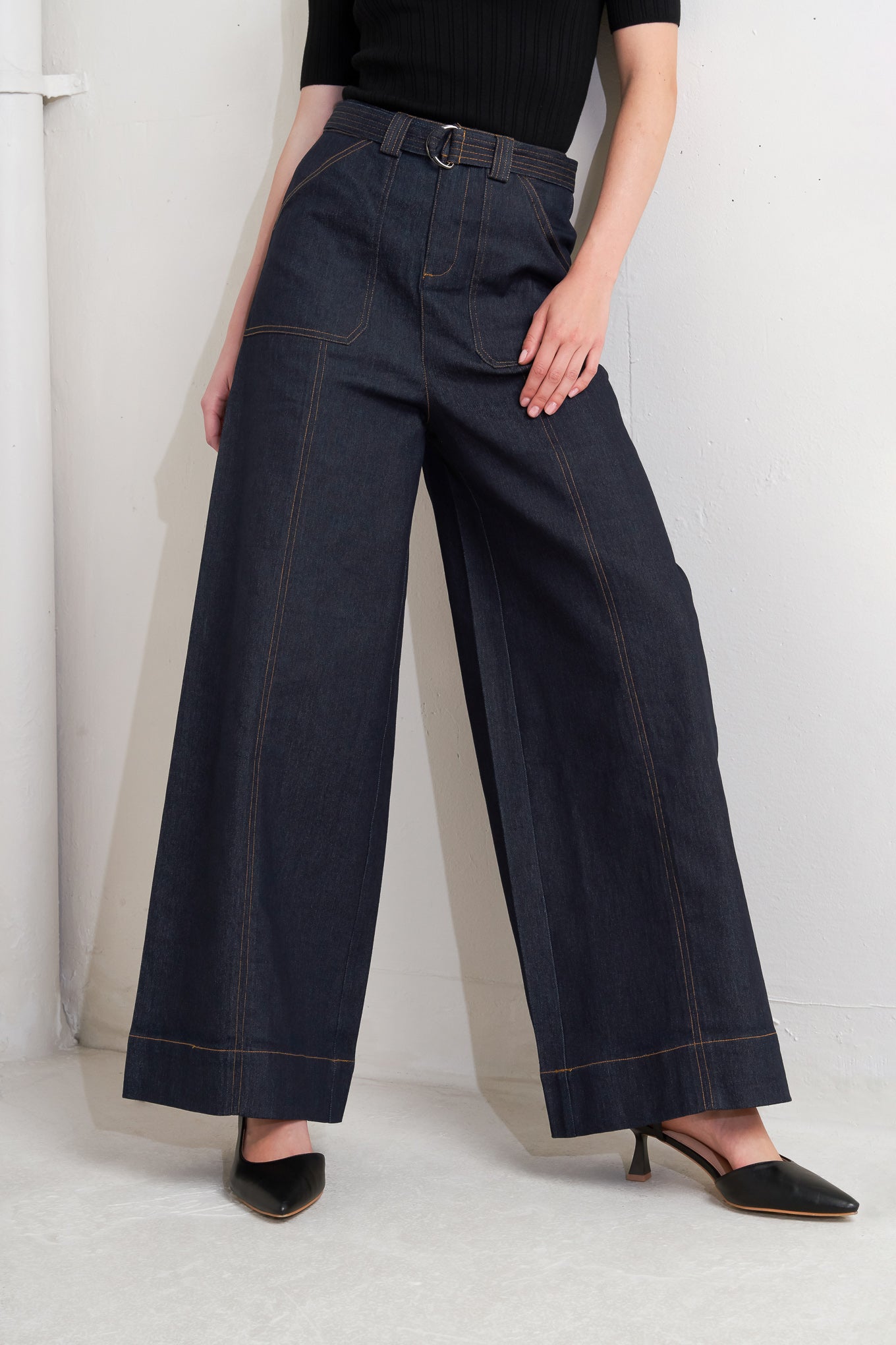 A denim pant featuring front closure, side pockets, self belt and wide