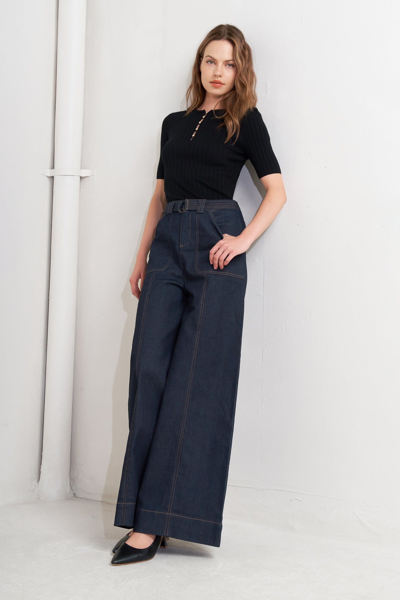 A denim pant featuring front closure, side pockets, self belt and wide