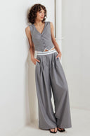A solid woven pant featuring front closure, side pockets, contrasting waistband and side stripes and wide leg. 