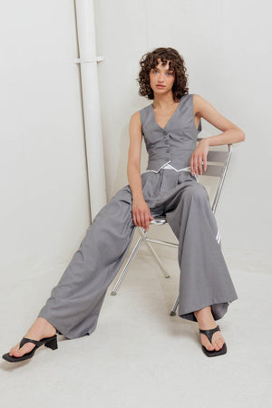 A solid woven pant featuring front closure, side pockets, contrasting waistband and side stripes and wide leg. 