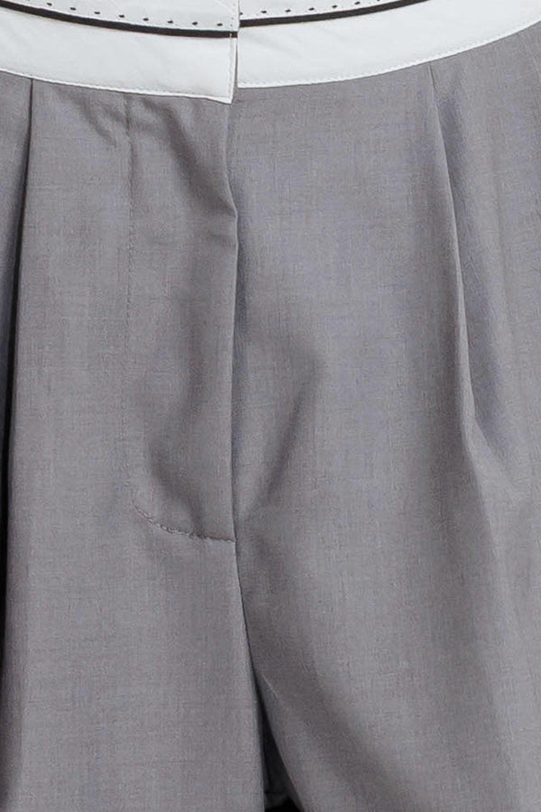 A solid woven pant featuring front closure, side pockets, contrasting waistband and side stripes and wide leg. 