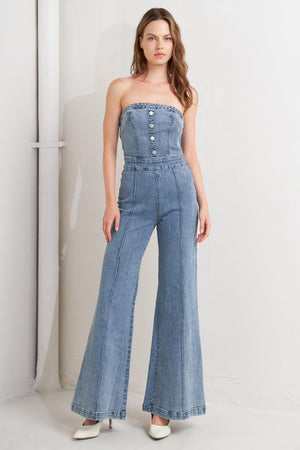 A washed denim jumpsuit featuring strapless, front button detail, wide leg and back zipper closure