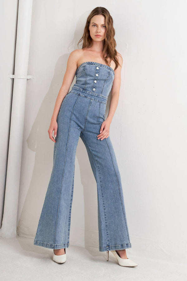 A washed denim jumpsuit featuring strapless, front button detail, wide leg and back zipper closure