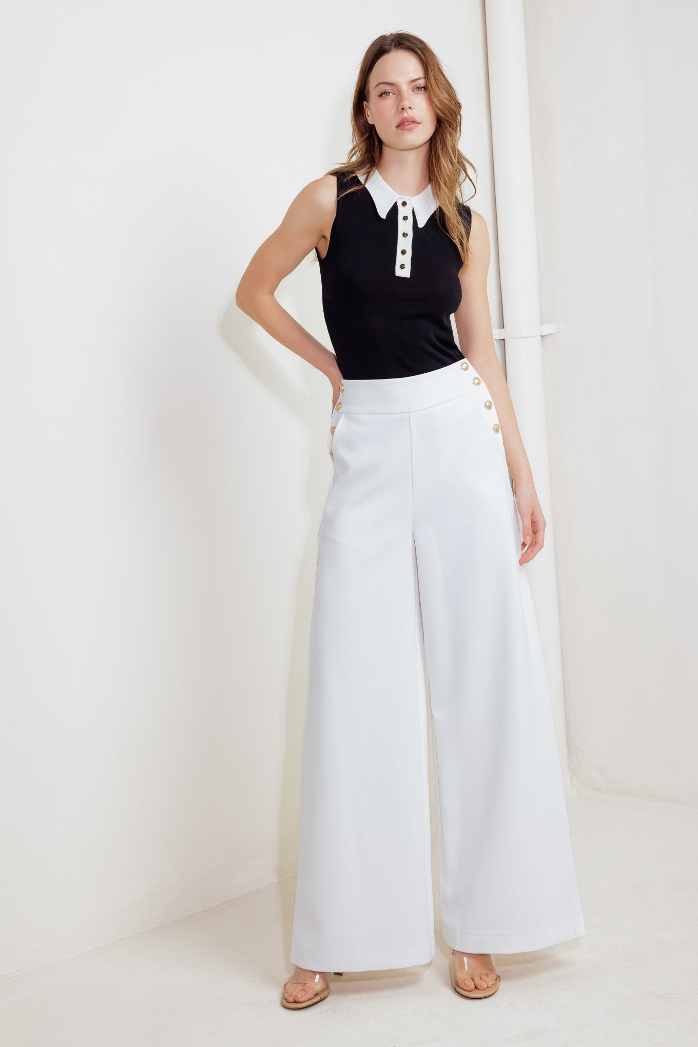 Woman wearing white wide-leg pants with gold button detail | FREEMARKET