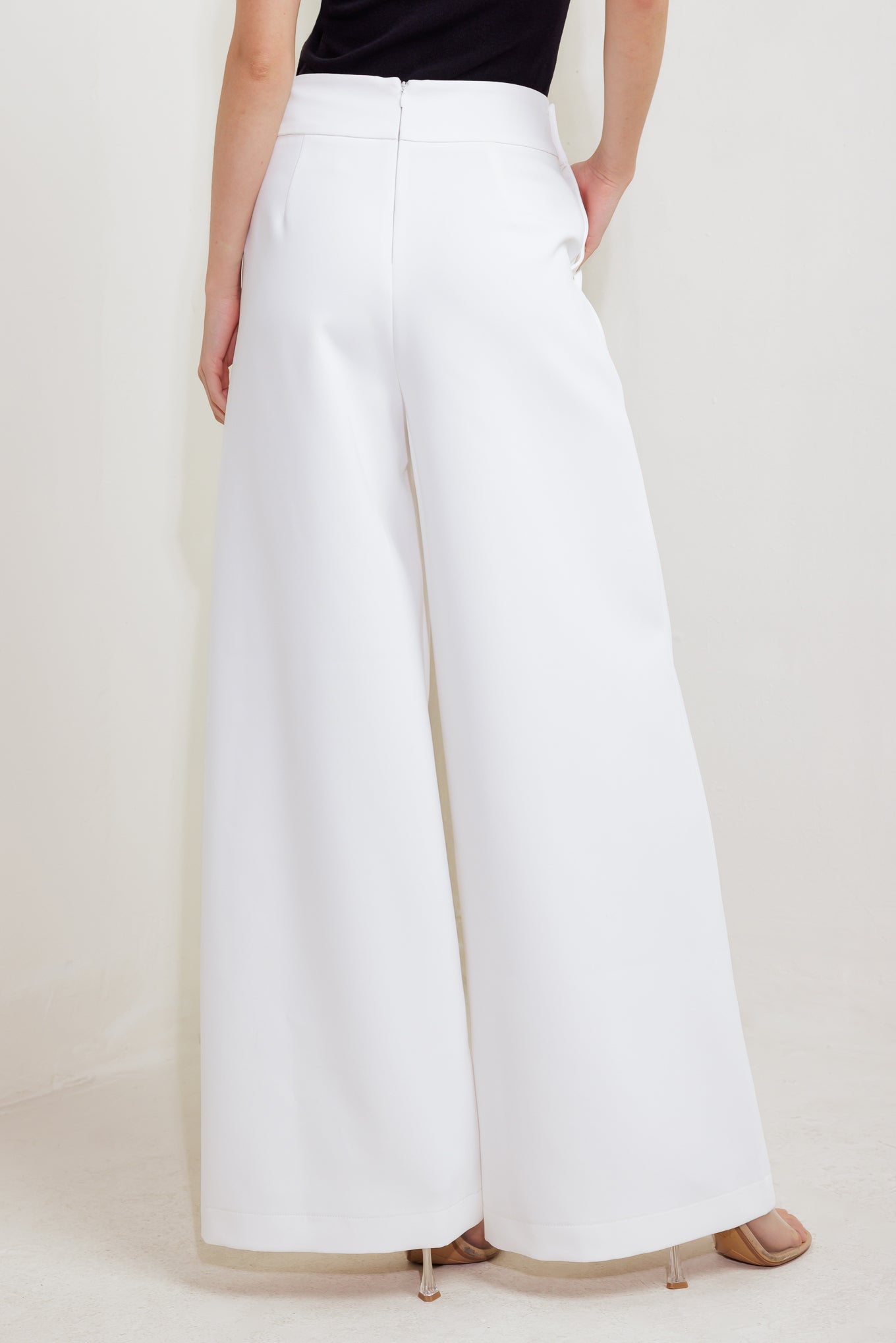 Woman wearing white wide-leg pants with gold button detail | FREEMARKET