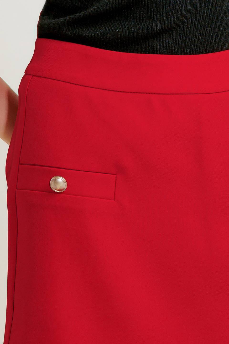 A solid red woven skort featuring side slit and back zipper closure