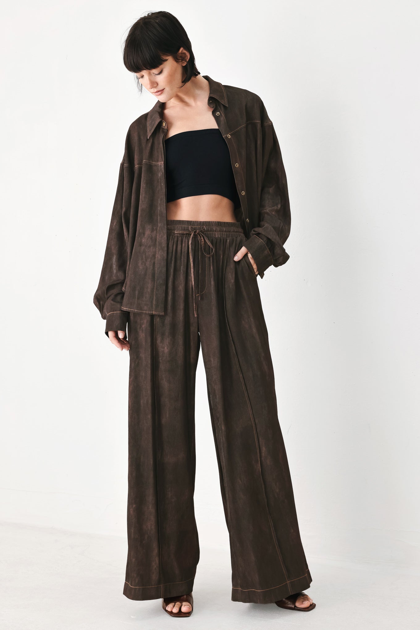 A woman wearing dark brown wide-leg drawstring pants with a mottled or washed texture | FREEMARKET