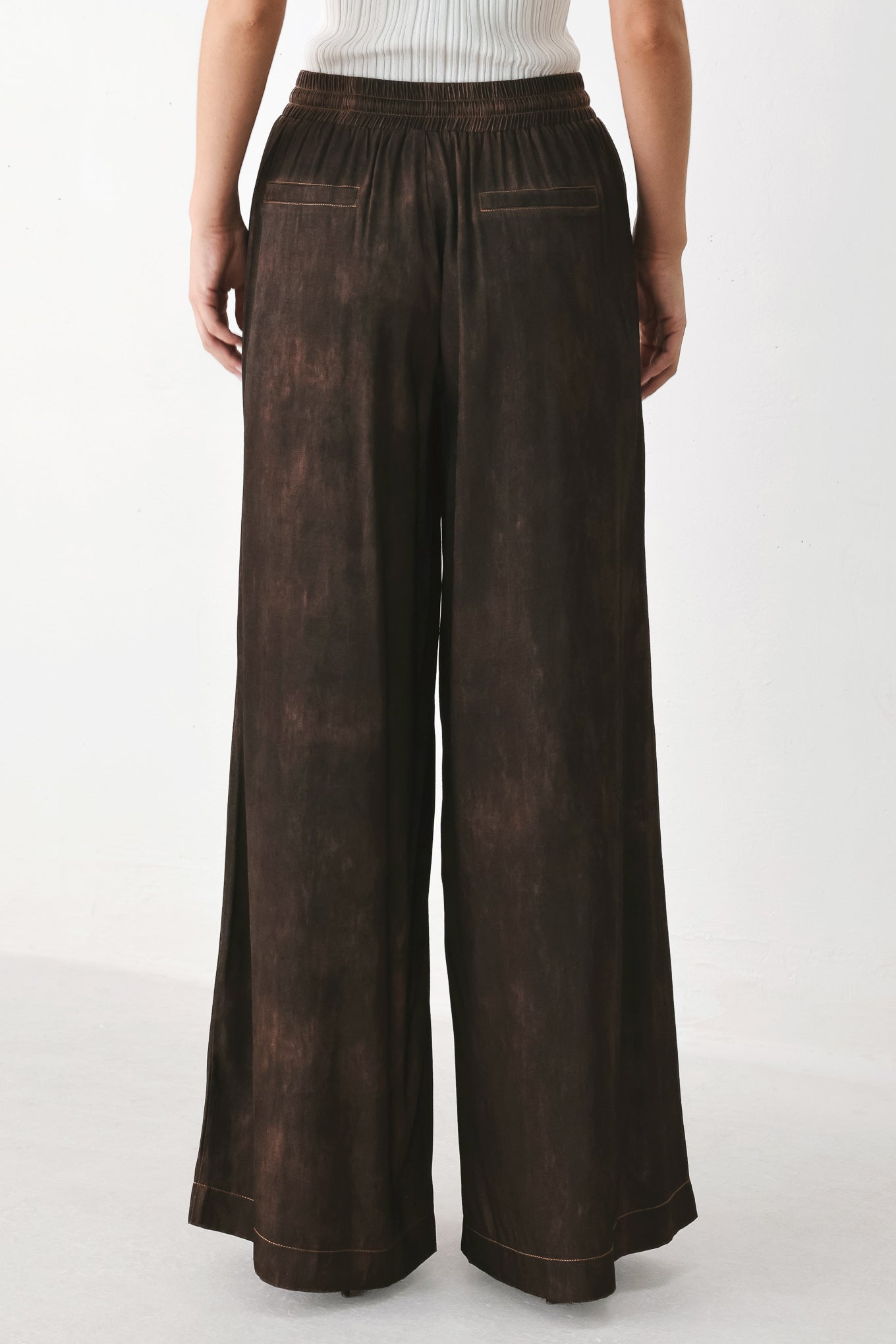 A woman wearing dark brown wide-leg drawstring pants with a mottled or washed texture | FREEMARKET