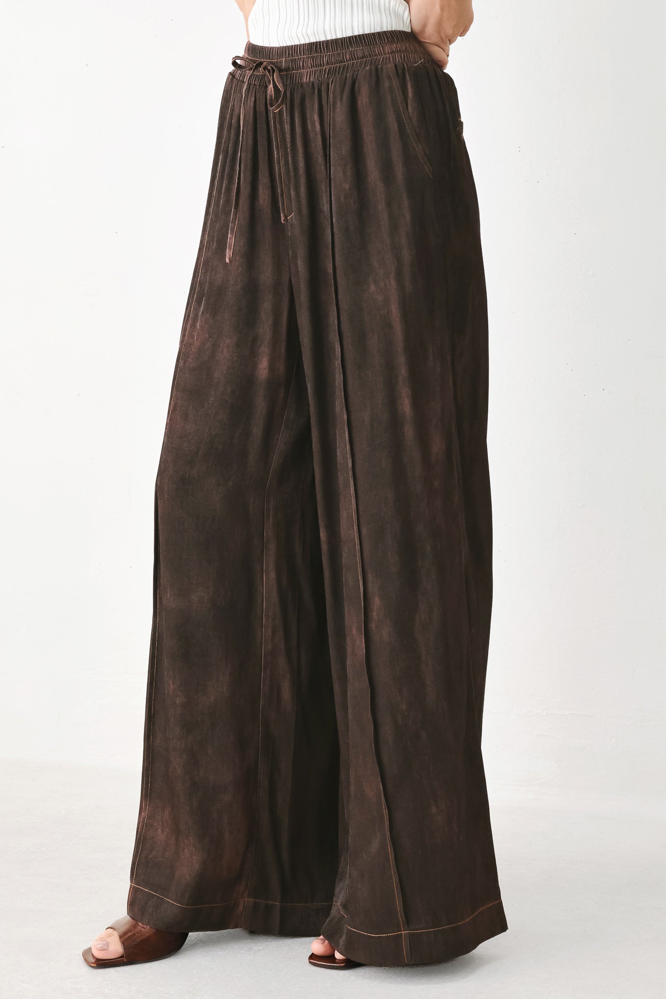 A woman wearing dark brown wide-leg drawstring pants with a mottled or washed texture | FREEMARKET
