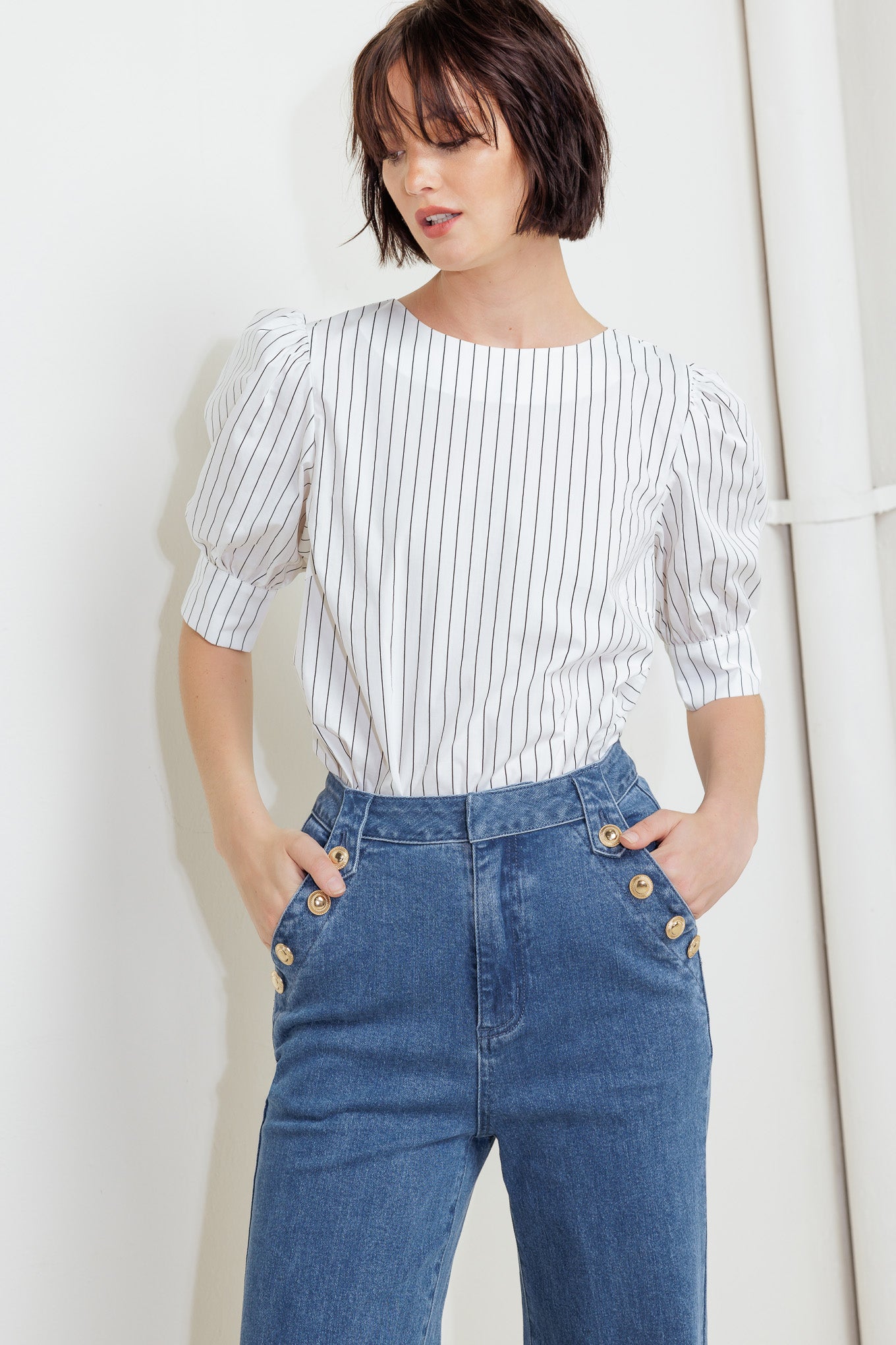 A washed denim pant featuring front closure, side pocket with button detail and wide leg with cuffed hem